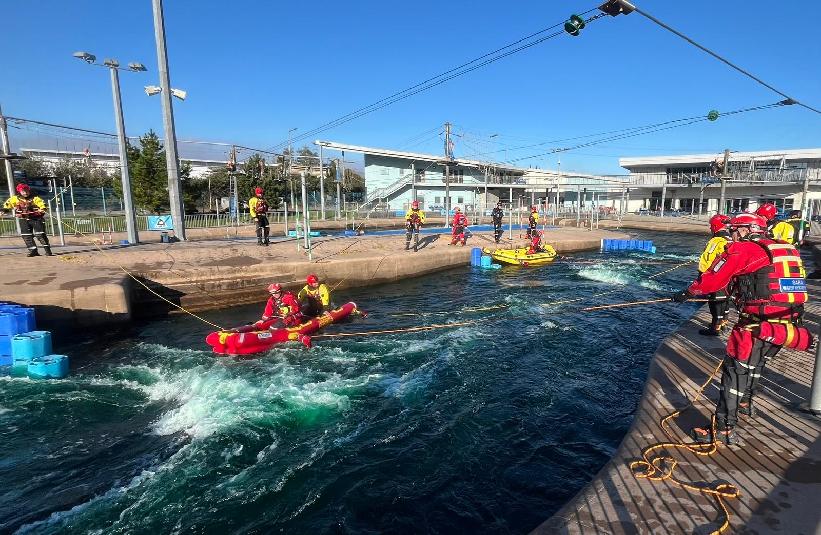 Emergency services practice hauling a raft in water