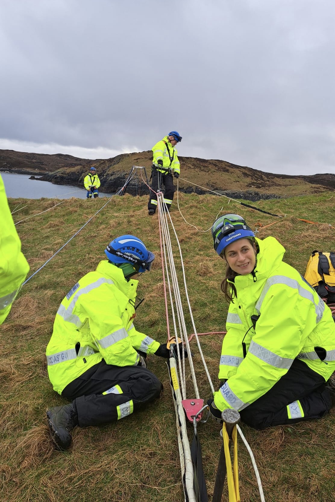 Coastguard Rescue Officer Karen Mackenzie crouched on the floor with team, holding rope equipment in place