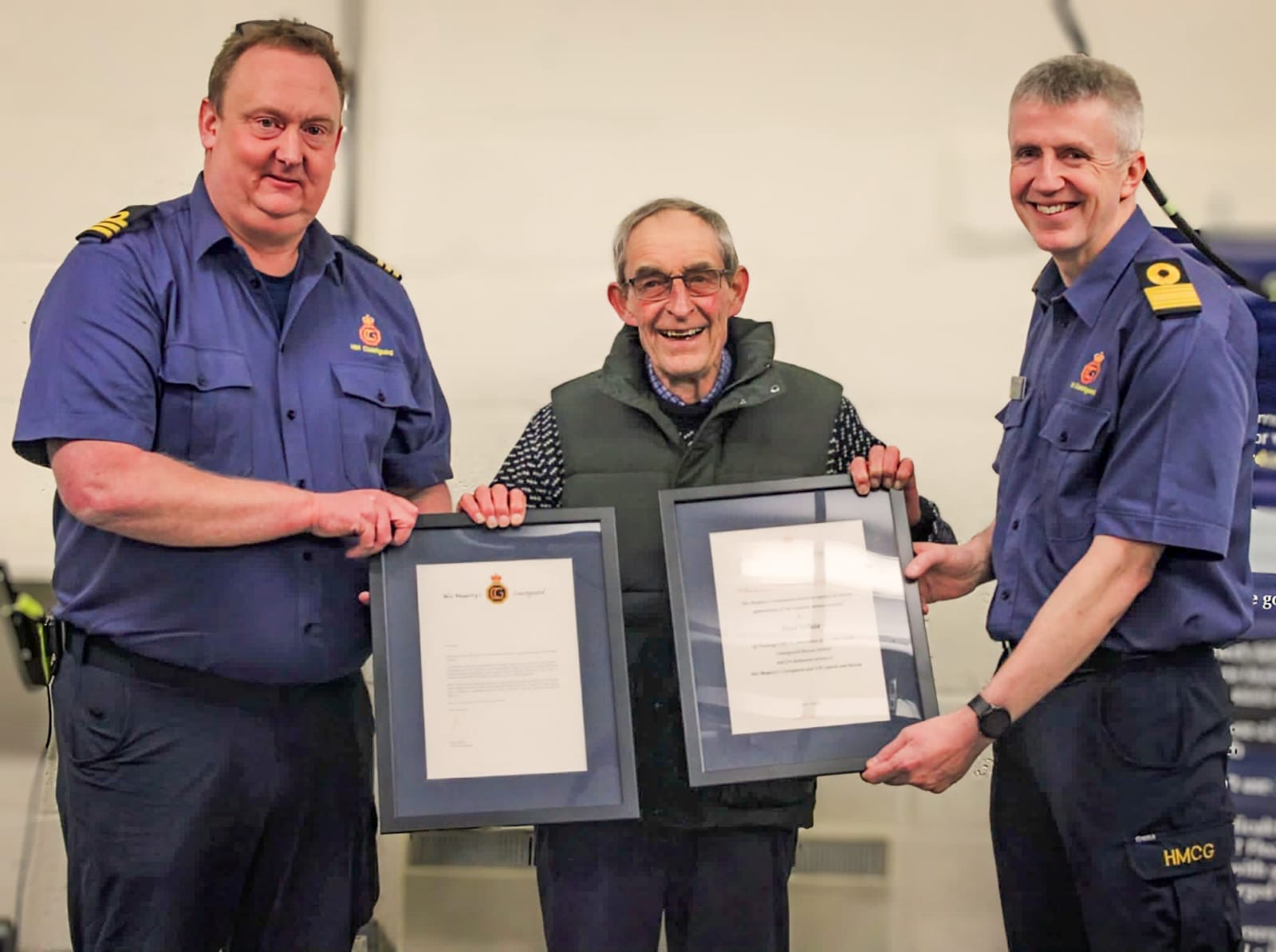 Senior HM Coastguard officers Matt Pavitt and John Craig present Paul 'Bud' White with letters of appreciation