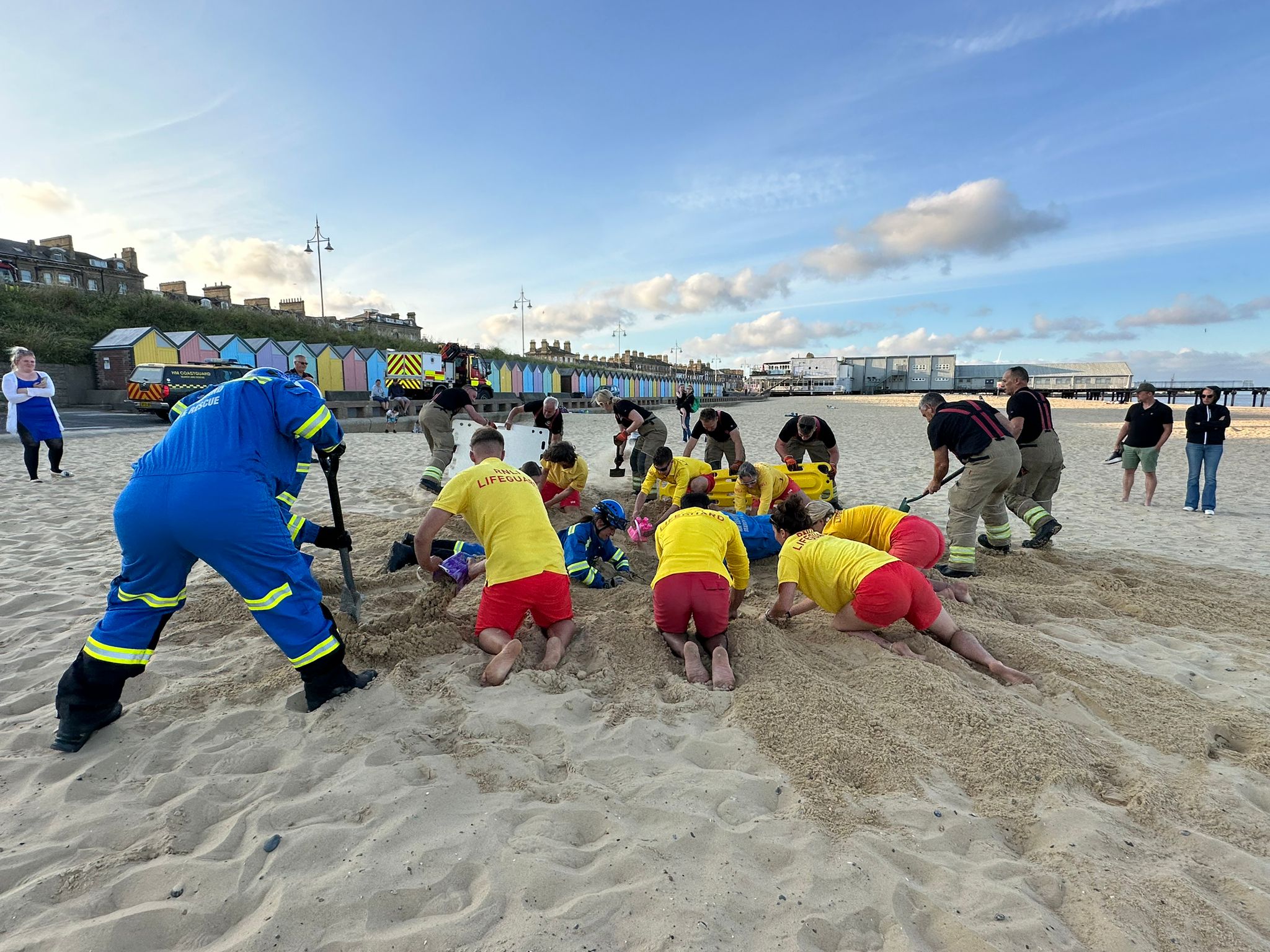 Coastguard Rescue Officers, lifeguards and firefighters practice a sand hole rescue