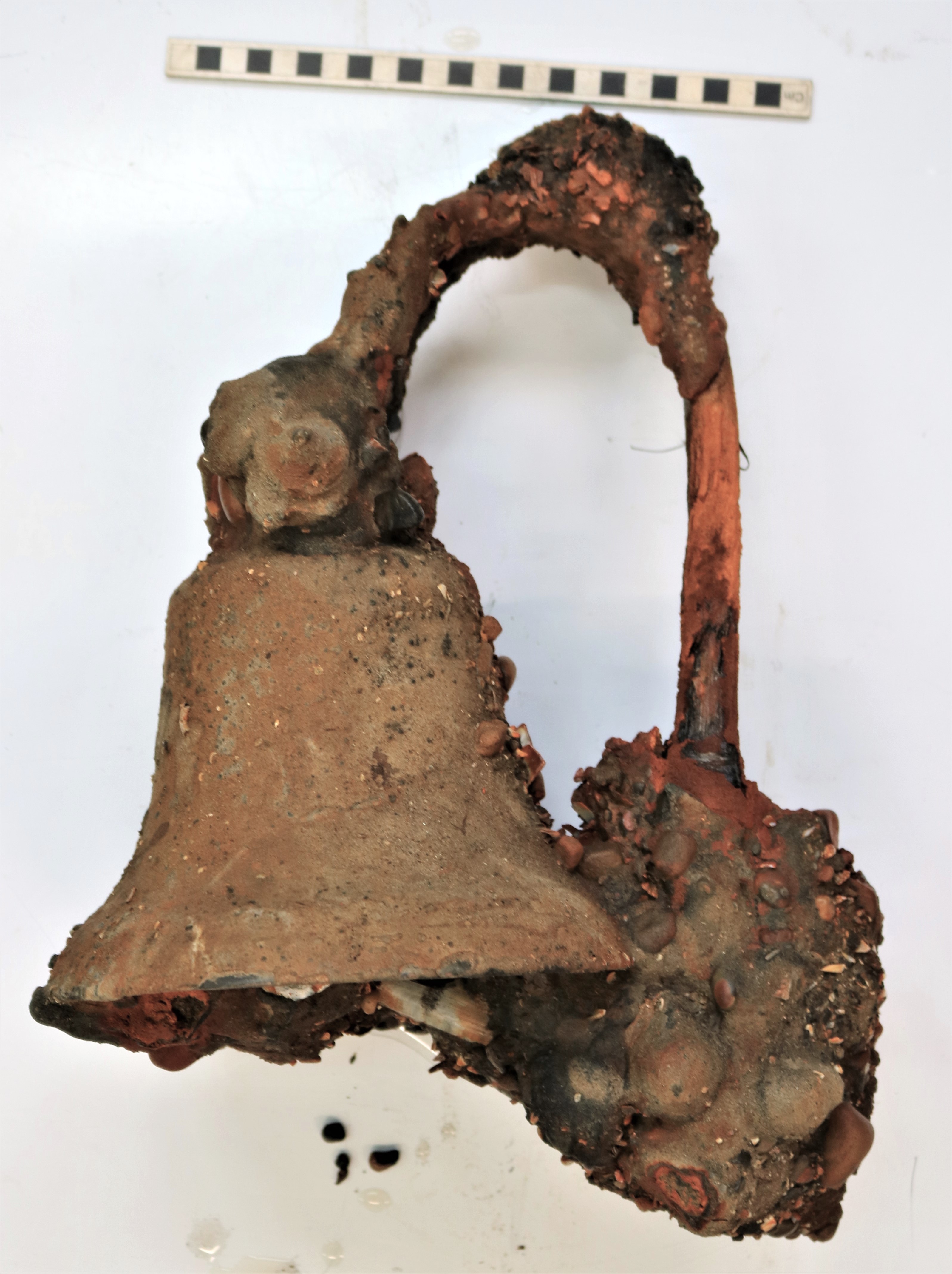 The ship's bell before conservation, encrusted with mud, sand and shells