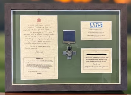 The plaque contained within a wooden frame