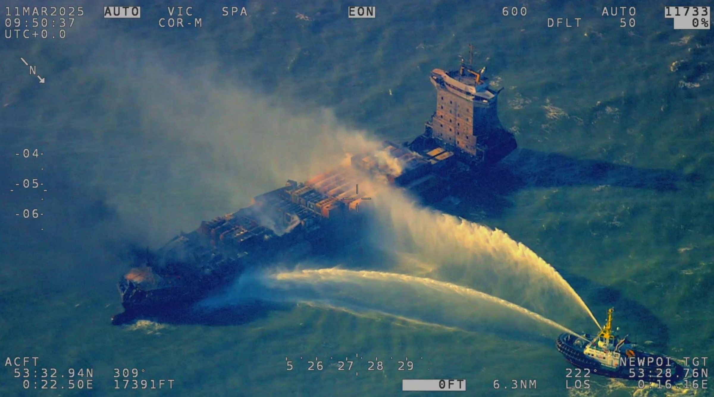 An aerial view of the SOLONG vessel with water being poured over it from a tug