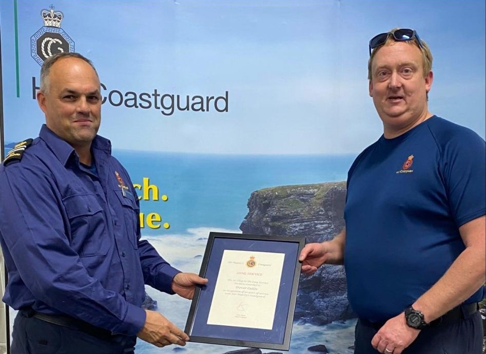 Two men in uniforms holding a certificate