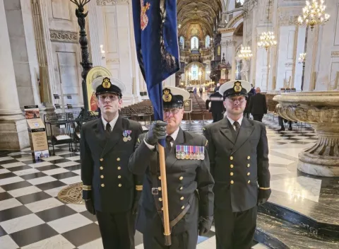 From left standing to attention at St Paul's Cathedral are Dan Foster, Kevin Moran holding the HM Coastguard colours, and George Belcher