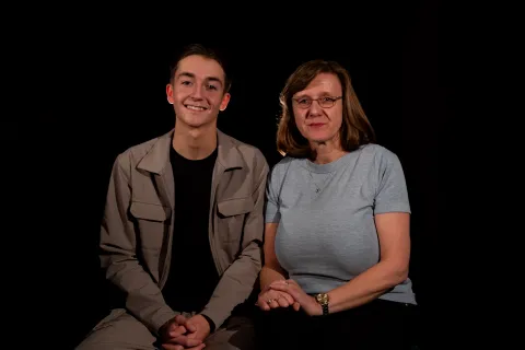 Joe Green and Vanessa Abbess sat next to one another against a plain, dark background