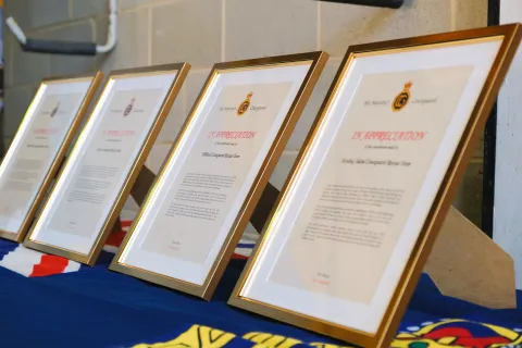 Framed awards of recognition lined up on a table