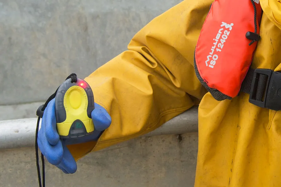 Fisherman holding personal locator beacon