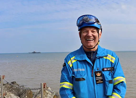 coastguard rescue officer stood in front of the sea