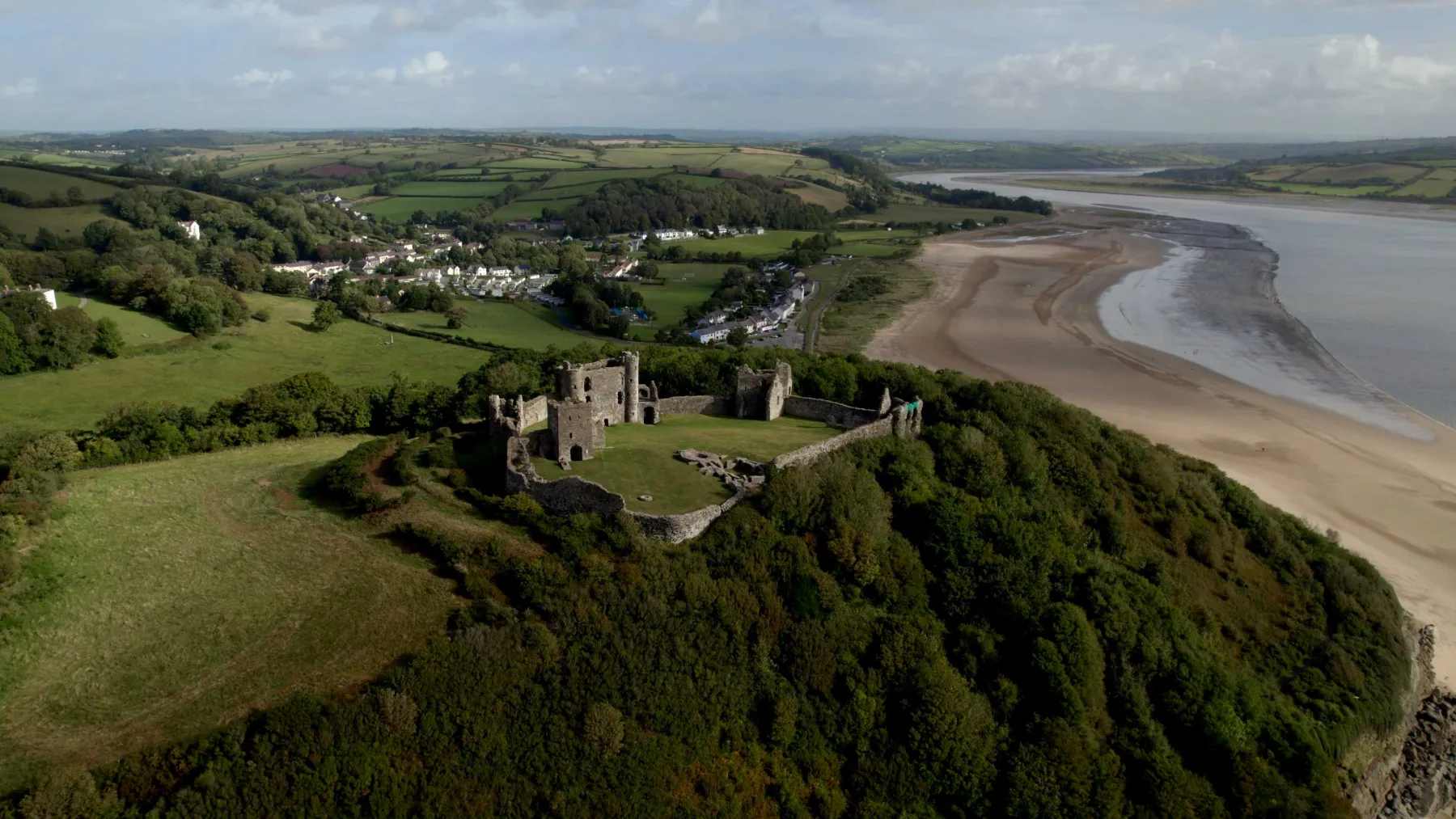 Aerial view of a coastal estuary with sand and a castle