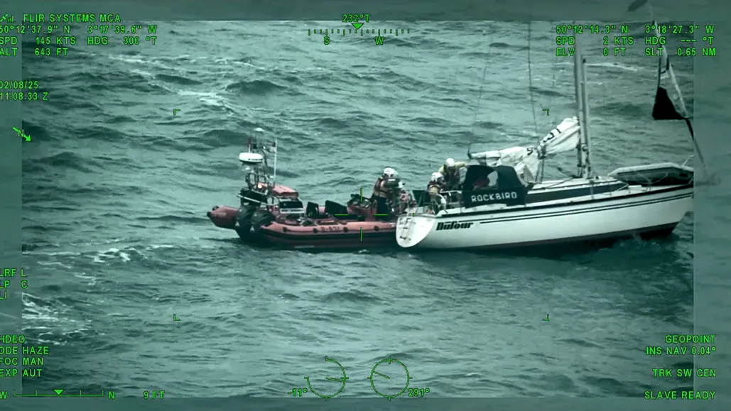 An RNLI lifeboat rescuing Richard Spreckley from his vessel during rough sea conditions