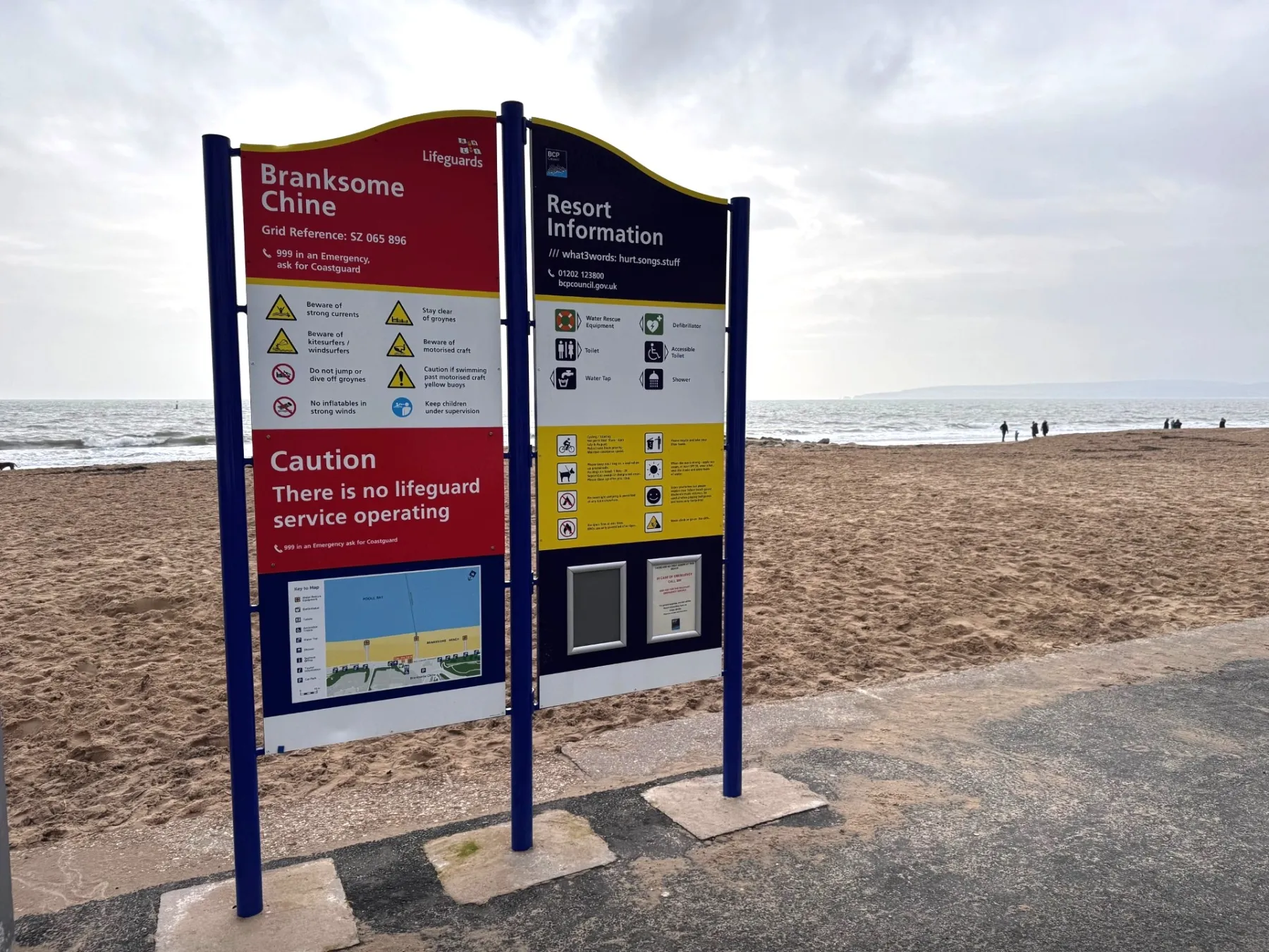 Image of a blue, yellow and white safety sign on a beach