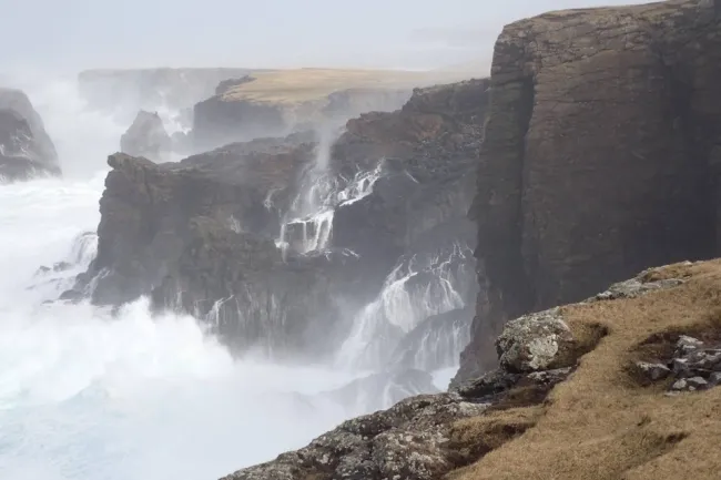 Waves crashing against cliffs.