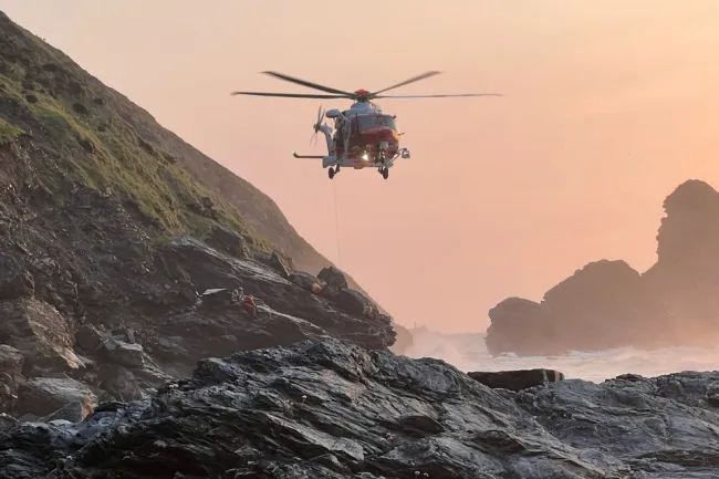 A Coastguard helicopter hovering at Bassets Cove, Portreath