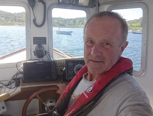 Hans Unkles behind the wheel of his electric fishing vessel, Lorna Jane