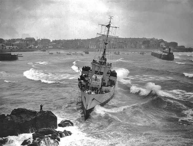 Coastguard Harry Barlow speaks with the captain of HMS Wave at St Ives